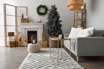 Interior of living room with fireplace, sofa and Christmas tree