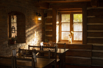 Bright morning light illuminates charming establishment with textured beams and comfortable seating for guests