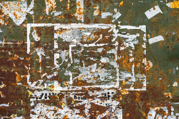 Rusty Grunge Wall with Torn Posters. Old metal surface with rust, peeling paint, ripped poster...