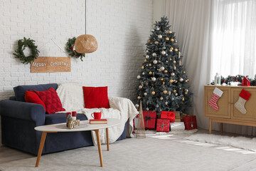 Interior of living room with Christmas tree, grey sofa and festive decorations