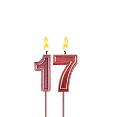 Candle number 17 - Lit birthday candle on white background