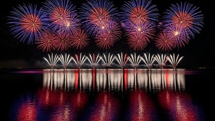 Stunning display of colorful fireworks exploding over a reflective body of water at night