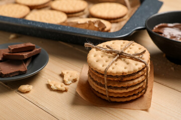 Stack of tasty sandwich biscuits on wooden background