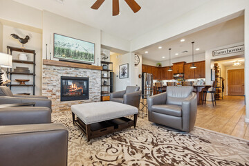 Living room with fireplace, chairs, coffee table, and ceiling fan