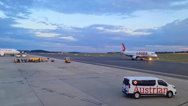 Vienna, Austria - 19. September 2025: Austrian Airlines van and Lauda plane taxiing at Vienna airport