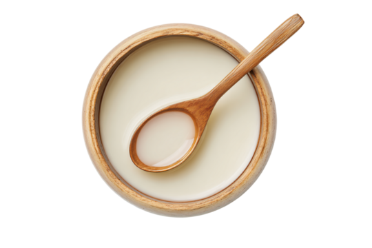 a wooden spoon sitting in a bowl of cream