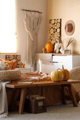 Interior of modern bedroom with comfortable bed, wooden bench and pumpkins