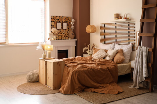 Interior of modern bedroom with comfortable bed, stepladder and chest of drawers