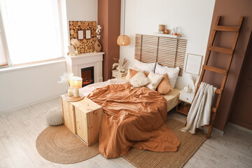 Interior of modern bedroom with comfortable bed, stepladder and fireplace