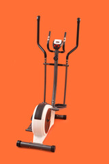 Modern exercising bike on orange background