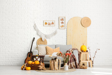 Interior of living room with sofa, picnic basket and autumn decor