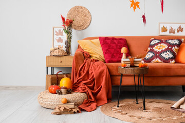 Interior of living room with sofa, tables and autumn decor
