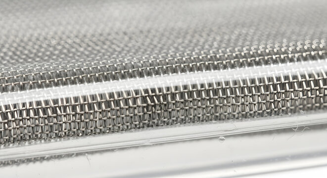 Macro view of shiny metal mesh grid pattern an industrial abstract background - Powered by Adobe