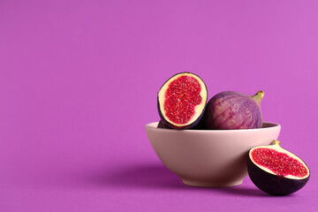 Bowl with fresh ripe figs on purple background