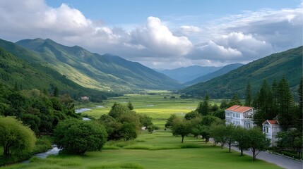 Scenic Highland Valley Landscape with Lush Greenery and Distant Mountains Under a Cloudy Sky Featuring a Small Town and a White Building