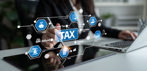 A tax consultant engages with a digital tablet displaying tax graphics and icons, symbolizing...