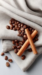 Styled Flat Lay of Roasted Coffee Beans and Wafer Rolls on Sparkling Silver Fabric with a Gray Textured Background