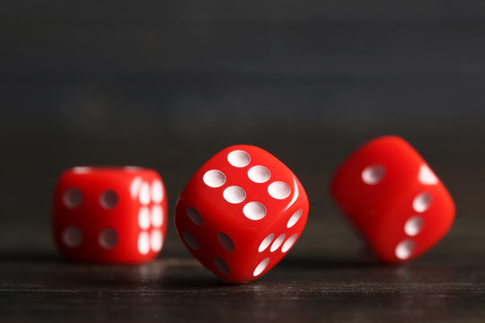Red game dices on wooden background, closeup