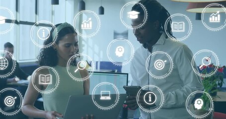 After pausing, two colleagues holding laptop and tablet analyzing business data with floating icons - Powered by Adobe