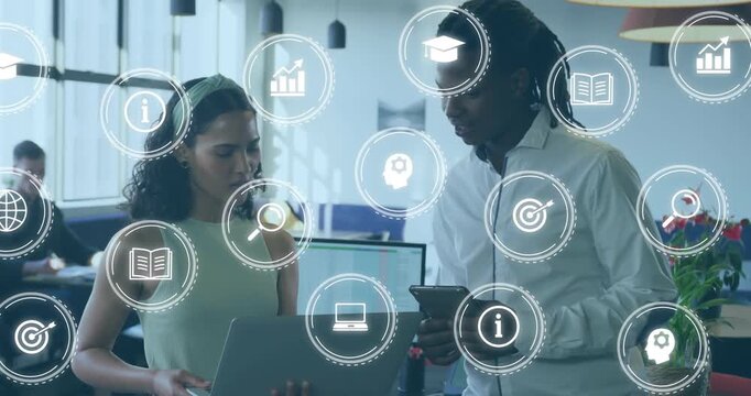 After pausing, two colleagues holding laptop and tablet analyzing business data with floating icons - Powered by Adobe