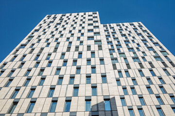 A tall building with many windows and a blue sky in the background