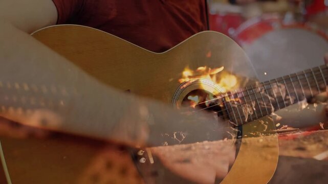 Guitarist picking acoustic guitar bringing flames while drummer tapping cymbals in music rehearsal