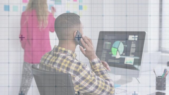 Woman reaching for sticky notes on business board while man discussing chart on phone for planning