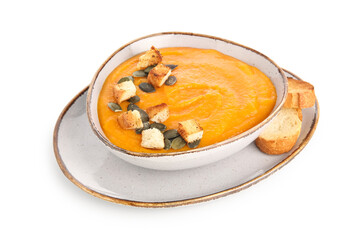 Bowl of delicious pumpkin cream soup with seeds and croutons on white background