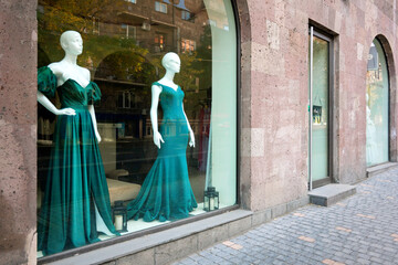 Naklejka premium A window display of green gowns in a store