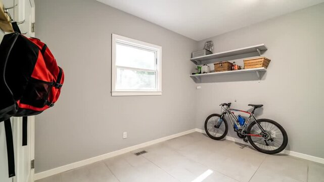 Interior room with bicycle and backpack organized storage space natural light from window