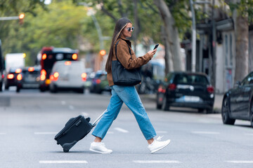 Pretty woman using her smartphone while walking through the city