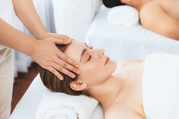 Caucasian couple enjoying relaxing anti-stress head massage and pampering facial beauty skin...