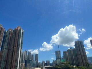 Fototapeta premium 青空と白い雲に包まれた香港の高層ビル街