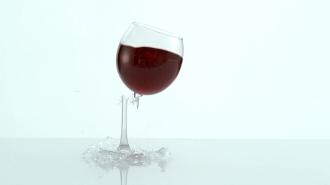 Glass of wine falling and breaking in super slow motion
