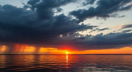 Dramatic sunset over the ocean with dark storm clouds and rain.