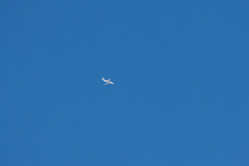 Fototapeta premium A white jet airliner against a clear blue sky