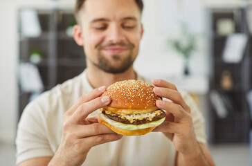 Close-up of young 30s smiling man holding juicy, freshly prepared, appetizing, homemade or...