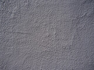 Close-up of a full frame rough, grayish wall surface. A rough wall texture for an abstract background.