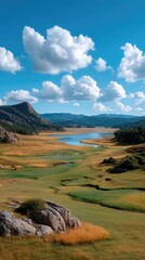 Vast Open Field Under a Dramatic Blue Sky with Puffy White Clouds and Distant Rocky Hills Reflected in a Serene Lake