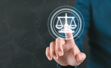 Law and justice merges with technology as finger touches glowing cyber law scale symbol representing lawyer services and ai in law innovation.