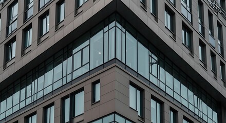Obraz premium Modern Urban Architecture - Corner of a Contemporary Building with Glass Windows and Dark Facade.