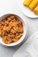 overhead view of Boiled ripe plantain with tomato scrambled eggs in a white bowl, top view of nigerian egg and plantain