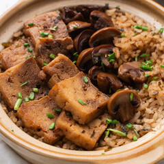 Overhead view of claypot rice with fried tofu and mushrooms in a donabe