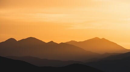 The scenery at sunset features an orange sky highlighting the contours of the mountains, which are gracefully serene, evoking a sense of tranquility and awe for the beauty of nature.