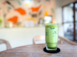 Refreshing Iced Matcha Latte Drink in Clear Glass on Wooden Table