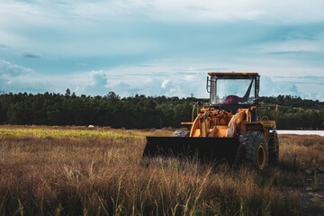 Fototapeta premium Agricultural Yellow Wheeled Loader with Black Bucket on Open Field