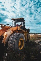Abandoned Yellow Heavy Wheel Loader Machine on Field Under Cloudy Sky