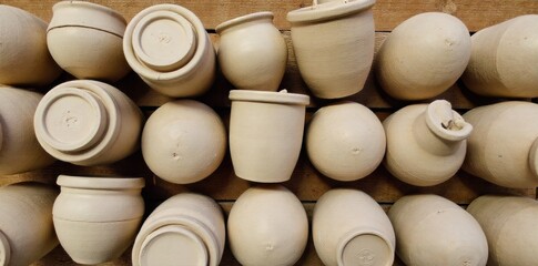 Ceramic Family of Pots A curated still life arrangement of diverse ceramic pots of varying sizes, shapes, and earthy colors. Some are glazed, some unglazed, showcasing subtle textures. They are neatly