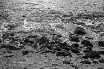 Ocean Shoreline with Sand and Rocky on the Beach in Black and White.