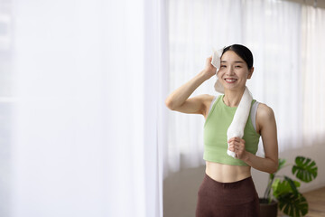 Smiling Japanese Woman Wiping Sweat with Towel After Workout